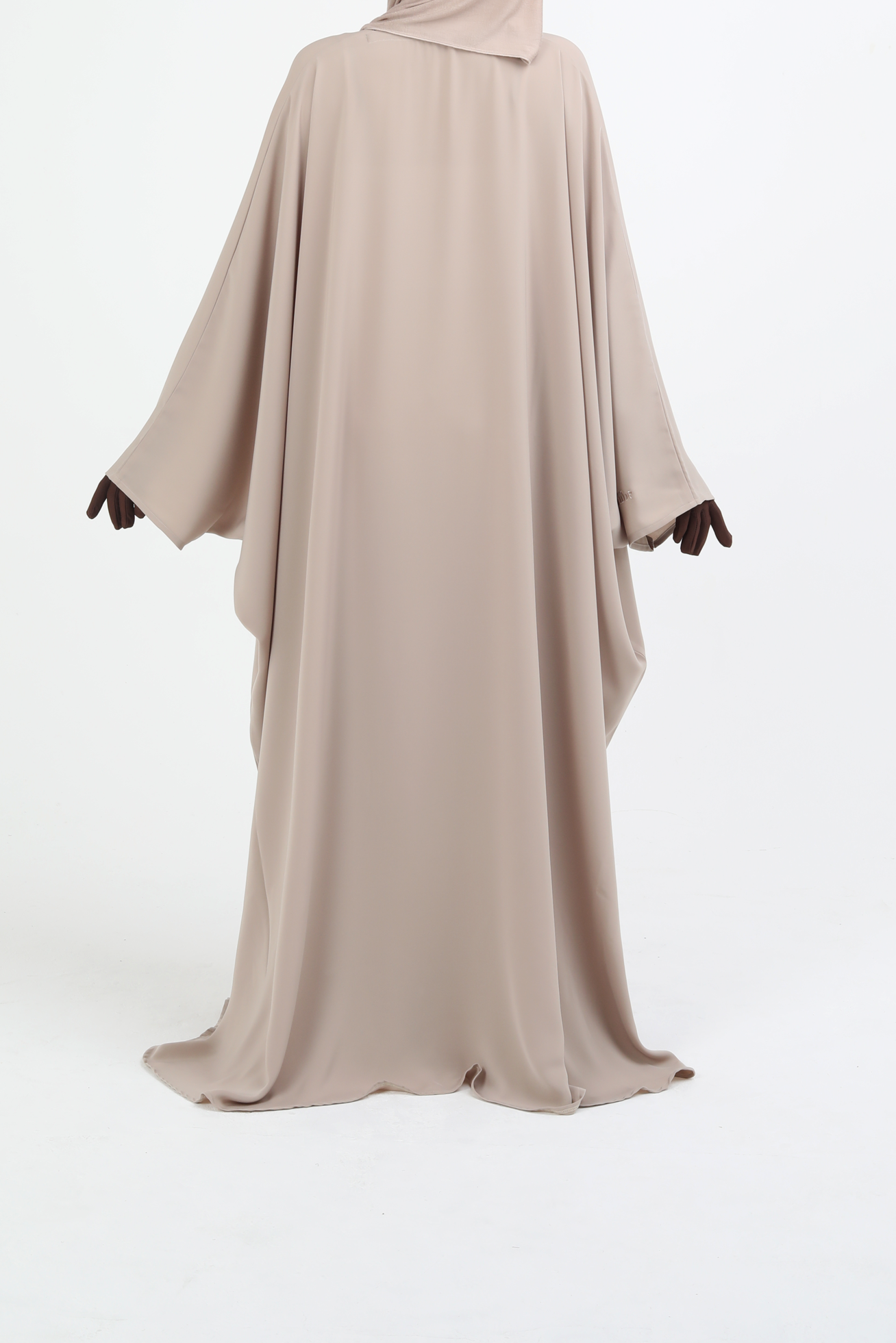 Beige abaya with matching hijab on a white background